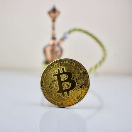Cryptocurrency physical gold bitcoin coin and small sisha.のeditorial素材