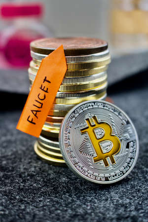 Digital currency physical silver bitcoin coin and faucet orange arrow.の写真素材