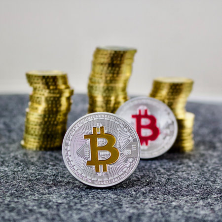 Cryptocurrency physical silver bitcoin coin with yellow and pink sign.の写真素材
