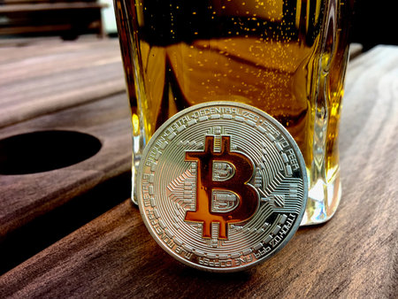 Cryptocurrency physical silver bitcoin coin and beer in glass