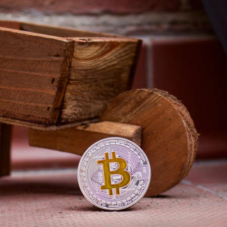 Cryptocurrency physical silver bitcoin coin near wooden trolleyの写真素材