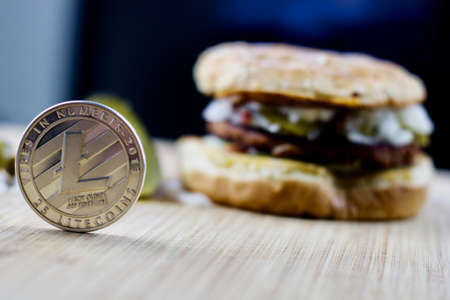 Cryptocurrency silver physical litecoin coin and veggie burger food.のeditorial素材