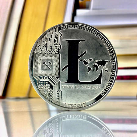 Cryptocurrency silver litecoin coin near booksのeditorial素材