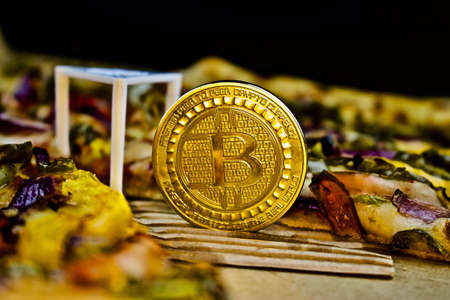 Cryptocurrency physical gold bitcoin coin near the pizzaの写真素材