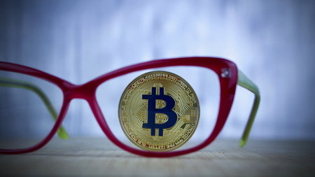 Digital currency physical blue bitcoin coin and pink glasses