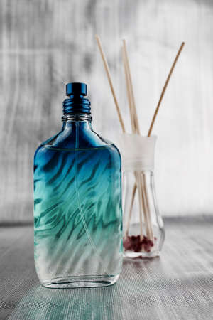 Fragrance composition. Blue perfume bottle on the tableの写真素材