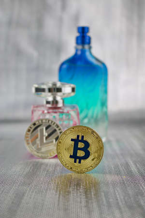Digital currency physical silver litecoin coin and gold bitcoin near perfumeのeditorial素材