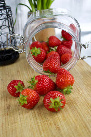 Red fresh strawberries in kitchen. Jar on the wooden board.の写真素材