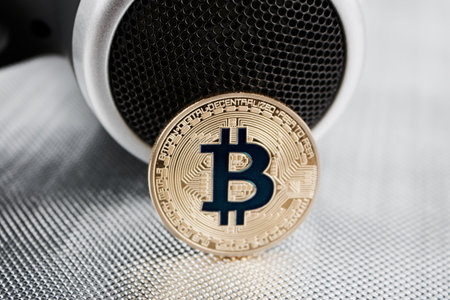 Cryptocurrency physical gold bitcoin coin near hairdryer.