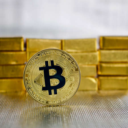 Cryptocurrency physical gold bitcoin coin near gold bars.のeditorial素材
