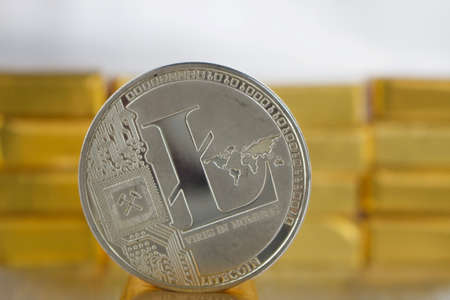 Digital currency physical silver litecoin coin near gold bars.のeditorial素材