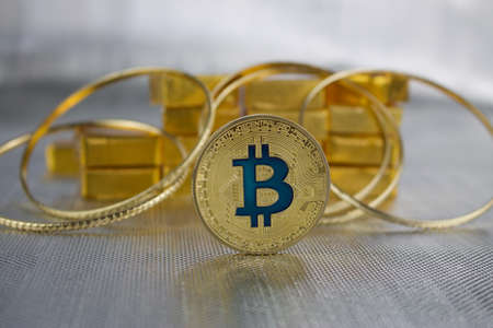 Cryptocurrency physical gold bitcoin coin near gold and rings.のeditorial素材