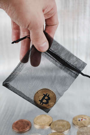 Digital currency physical gold bitcoin coin in black bag.の写真素材