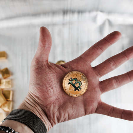 Cryptocurrency physical gold bitcoin coin on the hand.の写真素材