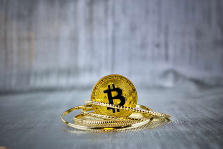 Cryptocurrency physical gold bitcoin coin in gold ringsの写真素材