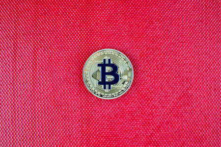 Cryptocurrency physical gold bitcoin coin on red scene. Blue bitcoin.の写真素材