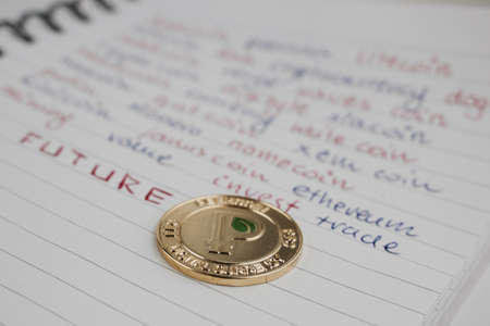Digital currency physical gold peercoin coin in notebook.のeditorial素材