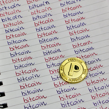 Digital currency physical small gold peercoin coin in bitcoin notebook.のeditorial素材
