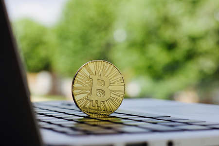 Cryptocurrency physical gold bitcoin coin on the black computer keyboard.の写真素材