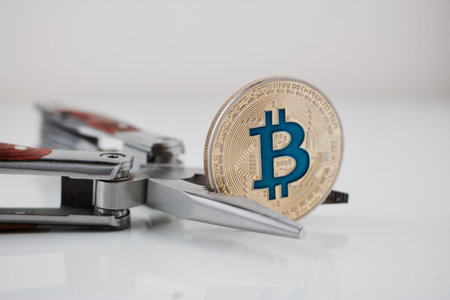 Cryptocurrency physical gold bitcoin coin and pocket knife on the table.