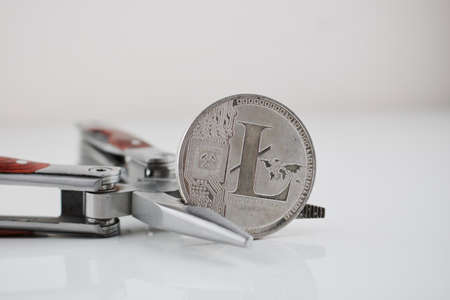 Digital currency physical silver Litecoin coin and silver pocket knife.の写真素材
