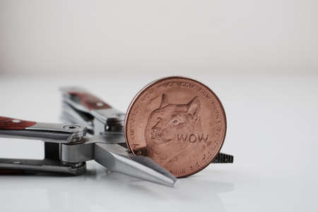 Digital currency physical brass dogecoin coin and silver pocket knife.の写真素材