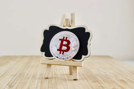 Digital currency physical red bitcoin coin on the wooden stand.の写真素材