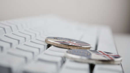 Europe leaving. Brexit physical coin on the white keyboard. British map.の写真素材