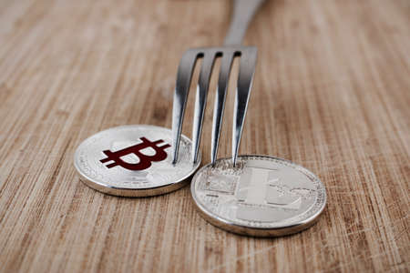 Cryptocurrency physical silver bitcoin coin and litecoin on the wooden board.の写真素材