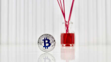 Digital currency physical blue bitcoin coin near red fragranceの写真素材