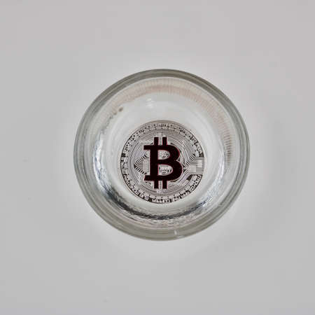 Digital currency physical silver bitcoin coin in glass jar on the white background.の写真素材