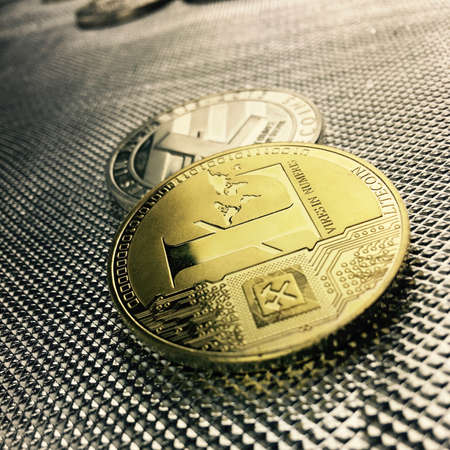Digital currency physical gold and silver Litecoin coin on silver background.のeditorial素材