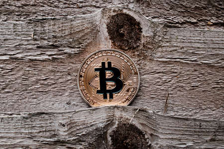 Digital currency physical gold bitcoin coin on the wooden background.の写真素材