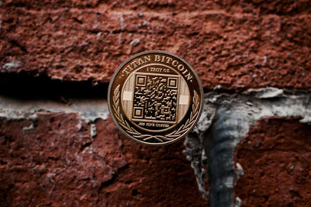 Cryptocurrency physical gold titan bitcoin coin on the brick wall.の写真素材