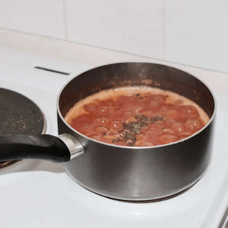 Cooking delicious tomato pasta in pot. Boiling red sauce in the kitchen.の写真素材