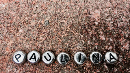 Small silver separate letters paulina inscription on dirty and old background.の写真素材