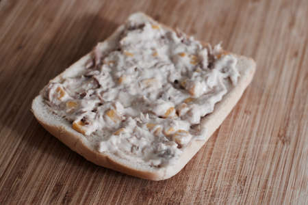 Tasty and fresh sandwich with tuna, butter and sweetcorn on the wooden board in the kitchen.の写真素材