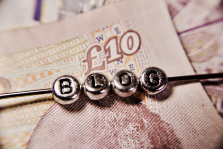 Small blog silver letters on ten pounds money background.の写真素材