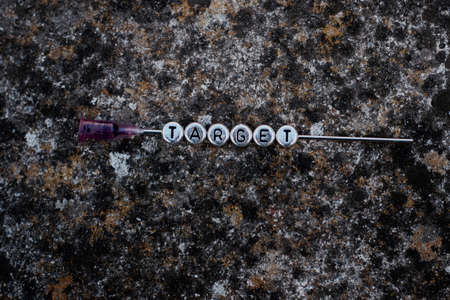 Silver inscription small letters target on the dirty background. Needle concept.の写真素材