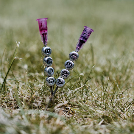 Small silver letters pins on the needle. Lena blog green grass outdoor concept.の写真素材