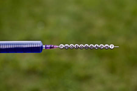 Silver inscription on the needle. Photography small letters pins on the green background.の写真素材