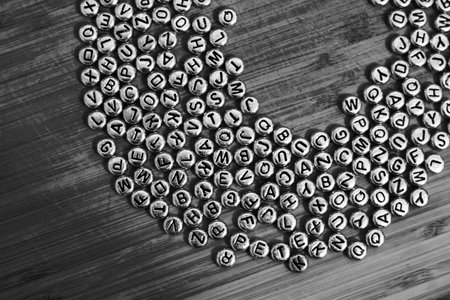 Small silver letters on the wooden background. Natural small letters.の写真素材