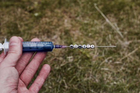 Small silver pins letters on the needle. Green grass natural outdoor concept.の写真素材