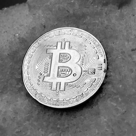 Digital currency physical metal coin on the white cristal background. Virtual cash concept.の写真素材