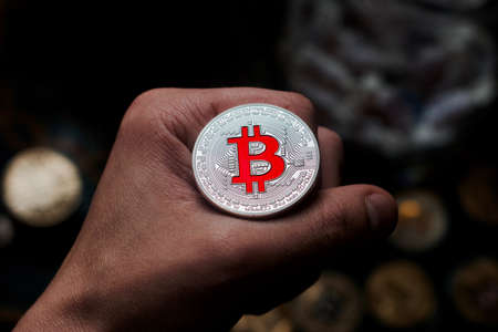 Digital currency physical metal bitcoin coin on man hand. Virtual cash concept.の写真素材