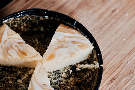 Delicious and fresh lemon cake slices in black circle box on the wooden board in kitchen.の写真素材