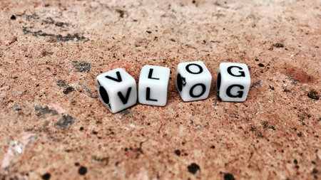 Vlog. White inscription. Small white square letters sign on the brown brick.
