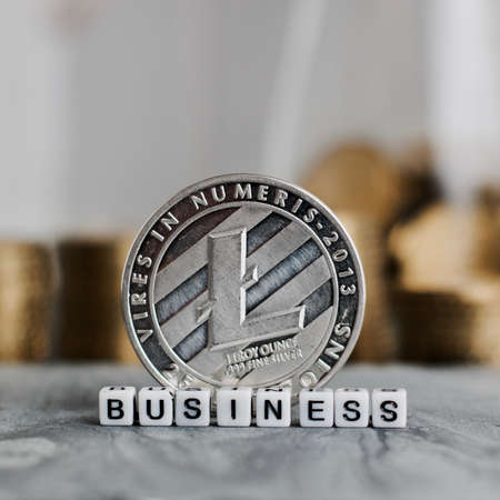 Digital currency physical metal litecoin coin near business white letters inscription.の写真素材