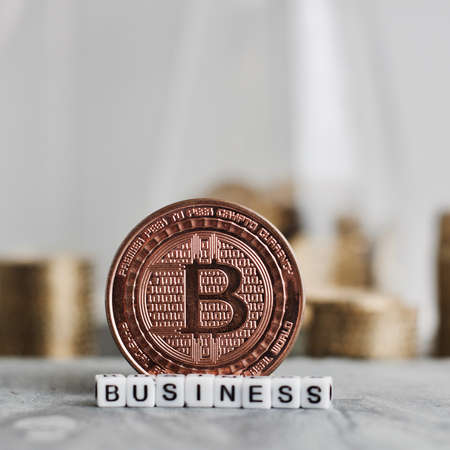 Digital currency physical metal bitcoin coin near business white letters inscription.の写真素材