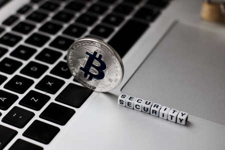Digital currency physical metal bitcoin coin on the keyboard. Bitcoin security.の写真素材